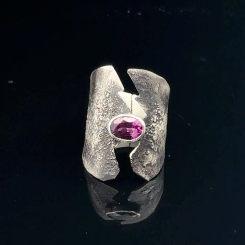 Sterling silver shield ring with almandine garnet center (size 6.5) on a black background front view. 