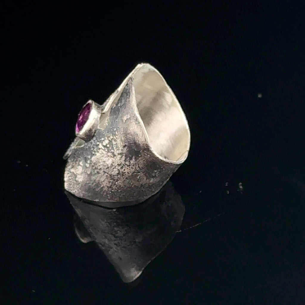 Sterling silver shield ring with almandine garnet center (size 6.5) on a black background, right side view. 