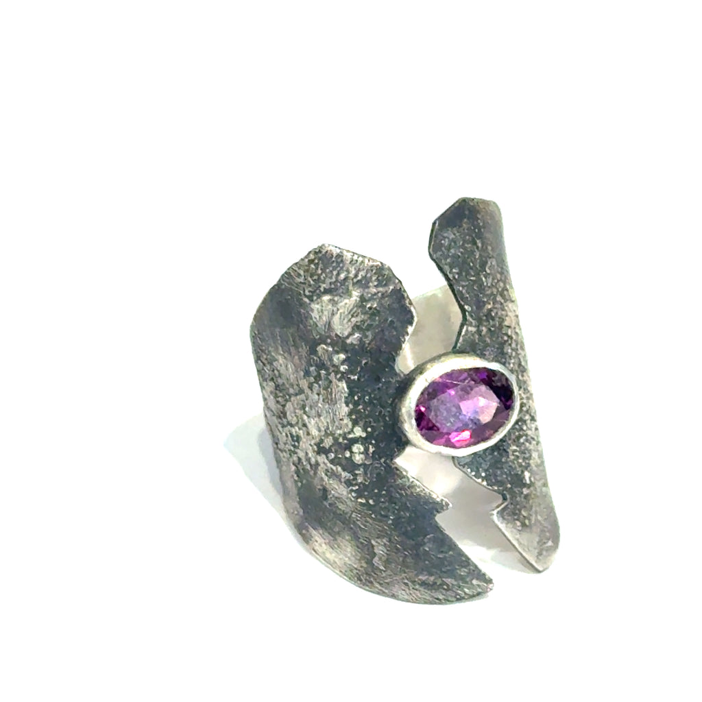 Sterling silver shield ring with almandine garnet center (size 6.5) on a white background, right angle  front, overview. 