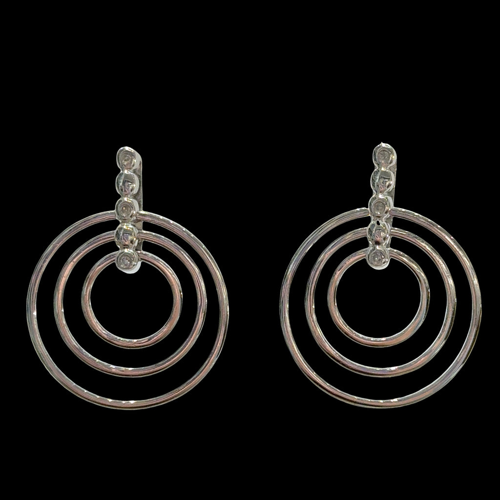 Sterling silver triple concentric circle stud earrings with three diamond accents on bar post on a black background, front view.
