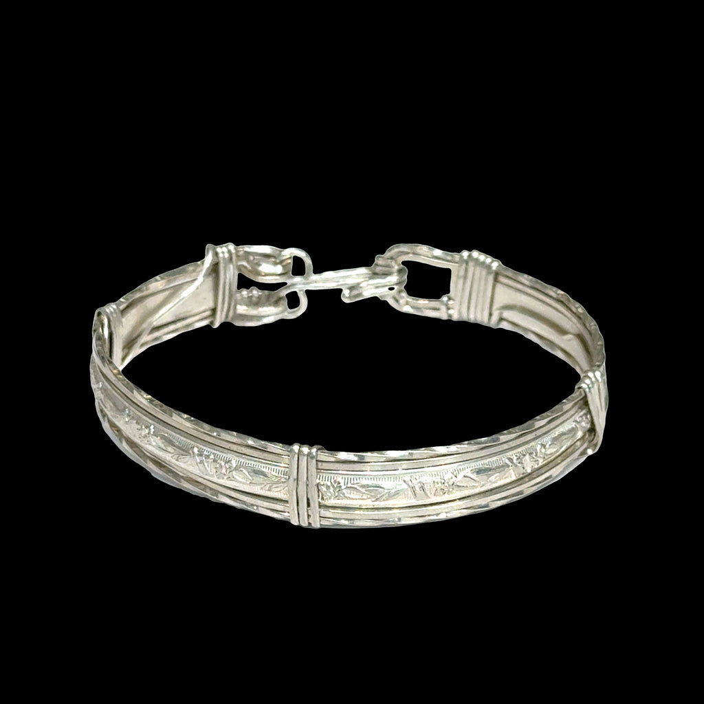 Style #3 Sterling silver bangle with twisted and straight wire featuring line-designed centerpiece showing elegant classic design, on a back background, front close up view. 