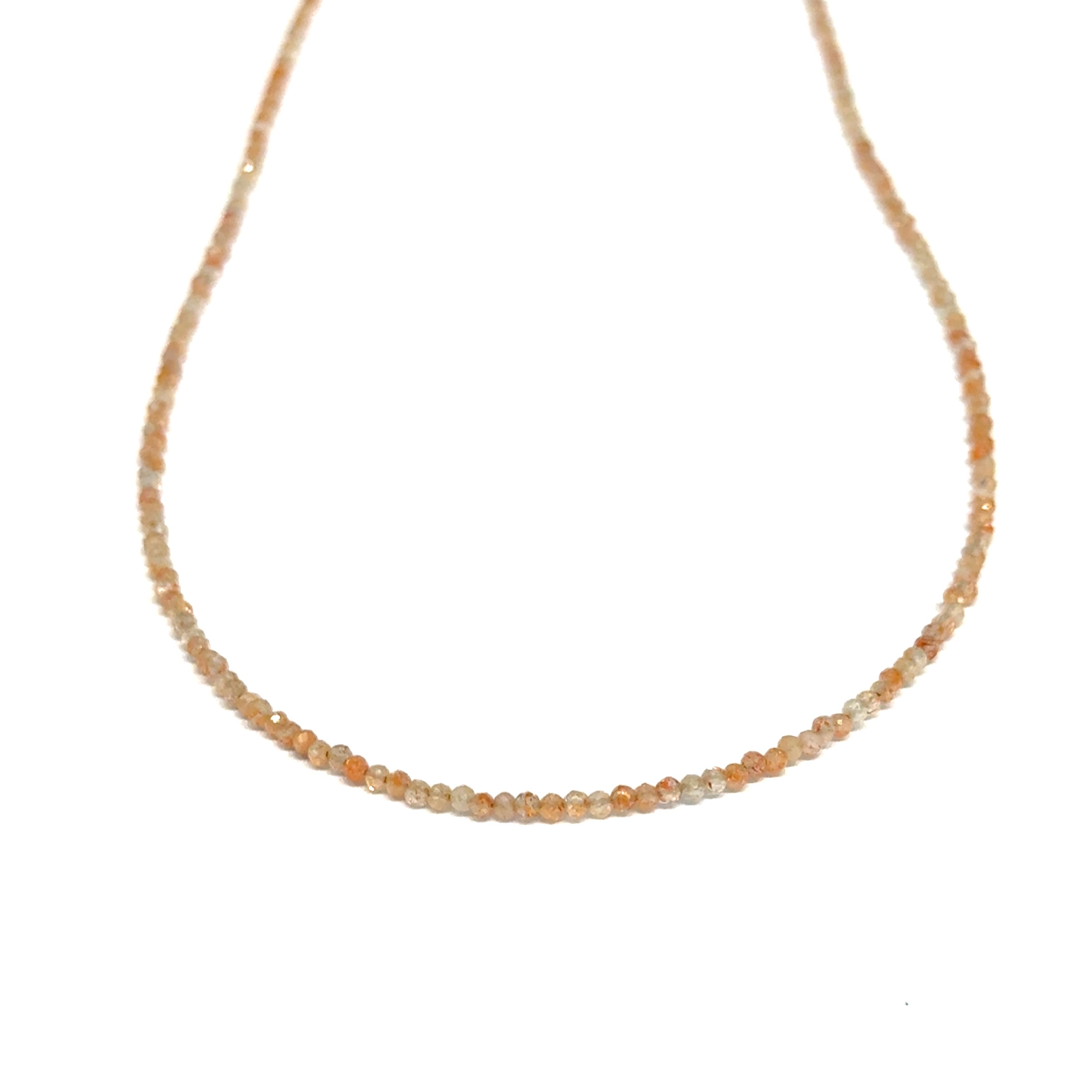 Sunstone necklace detail showing gold-filled clasp and warm peachy-gold round beads on a white background, front long hanging view. 