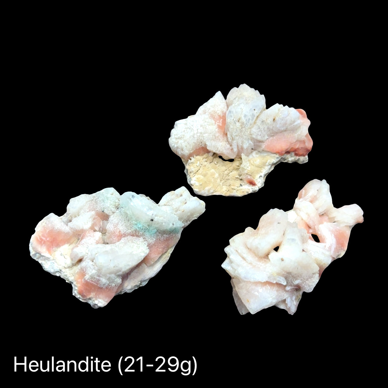 Three Ethically sourced Siberian heulandite specimen for heart chakra healing (21-29g) on a black background, front overview. 