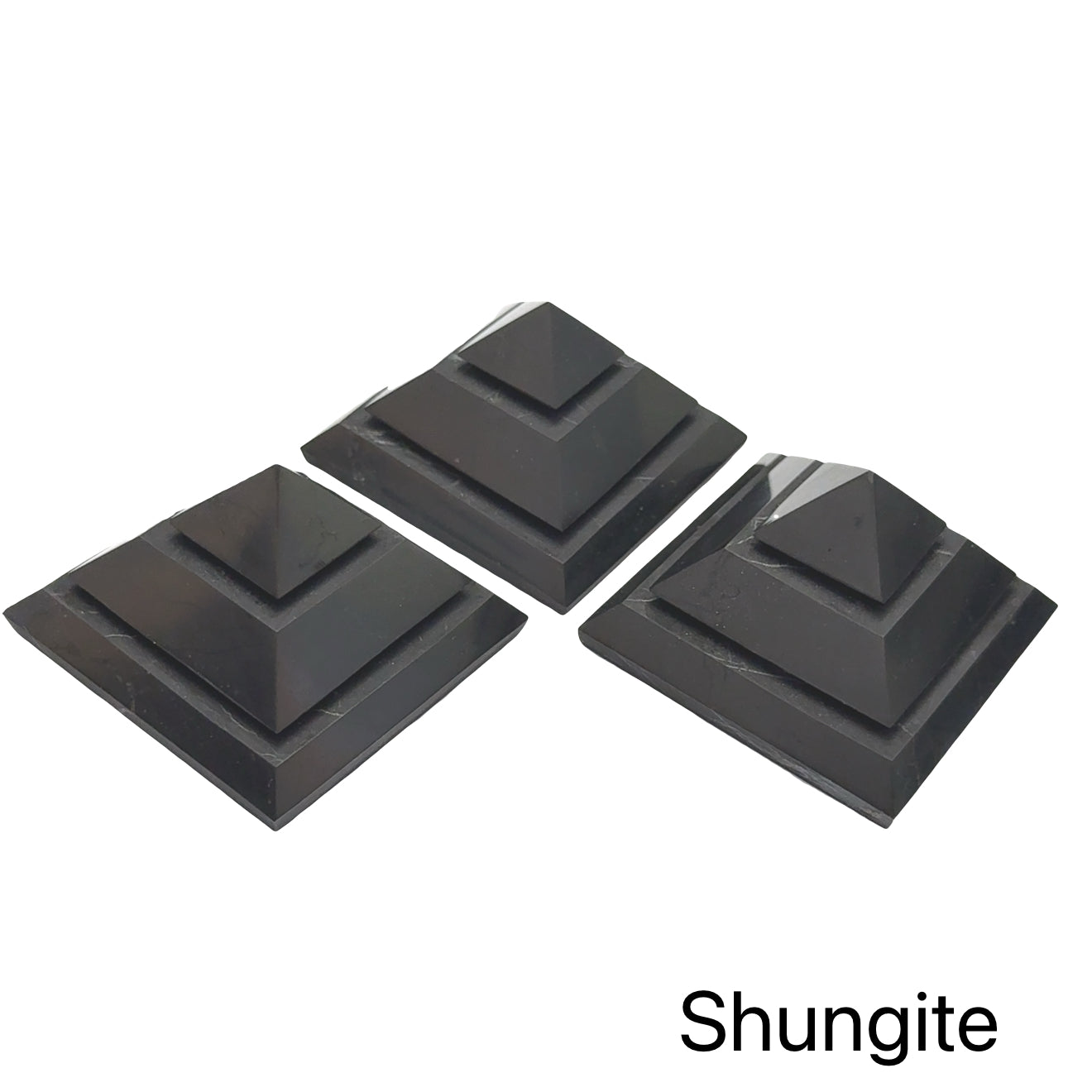 Three Extra Large Black Shungite pyramid for EMF protection and electromagnetic shielding on a white background, front view.