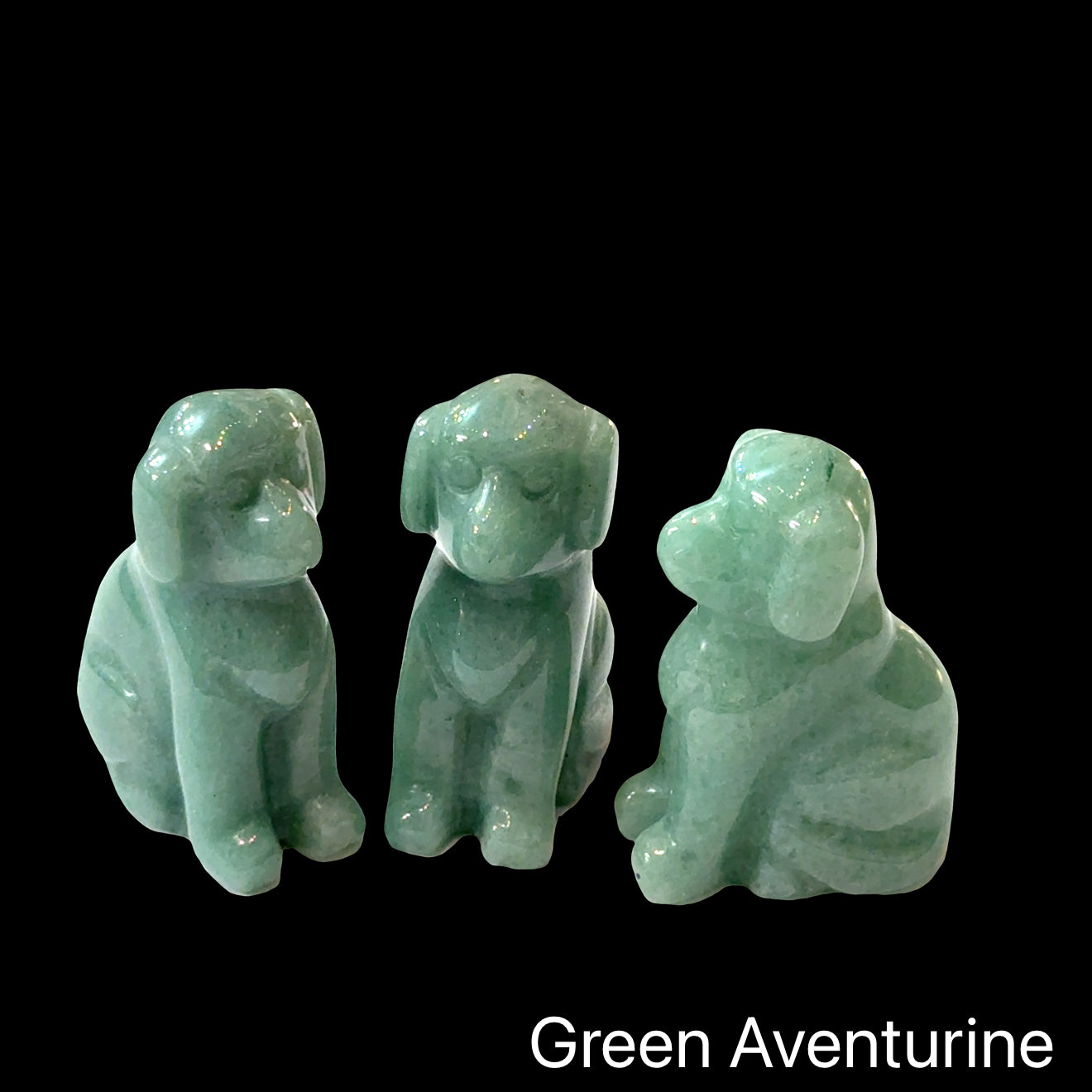 Three  Green Aventurine hound Dog gemstone carving on Black background, front view.