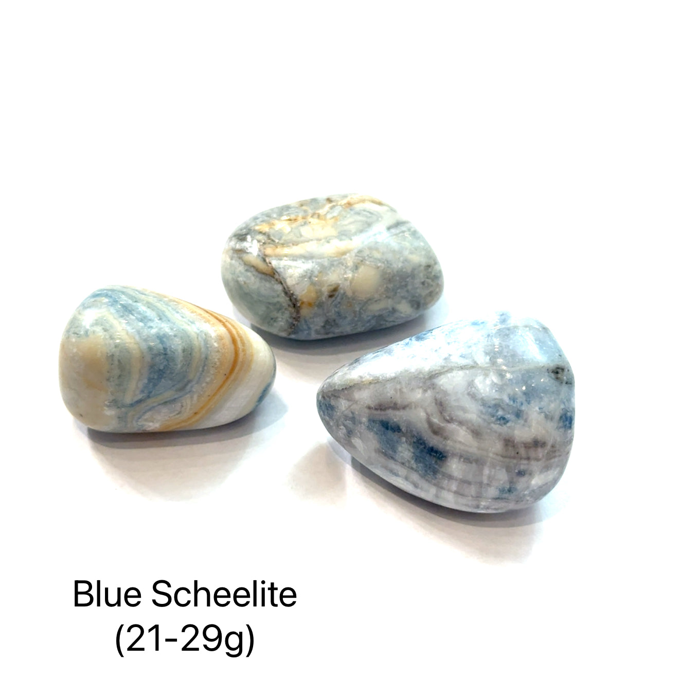 Three blue scheelite stones on a white background with text indicating the weight range of (21-29g), overview.