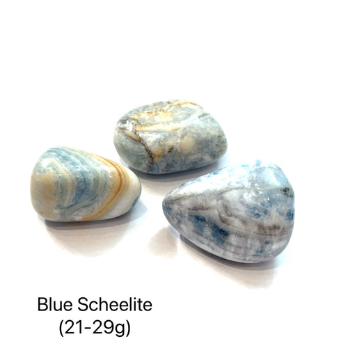 Three blue scheelite stones on a white background with text indicating the weight range of (21-29g), overview.