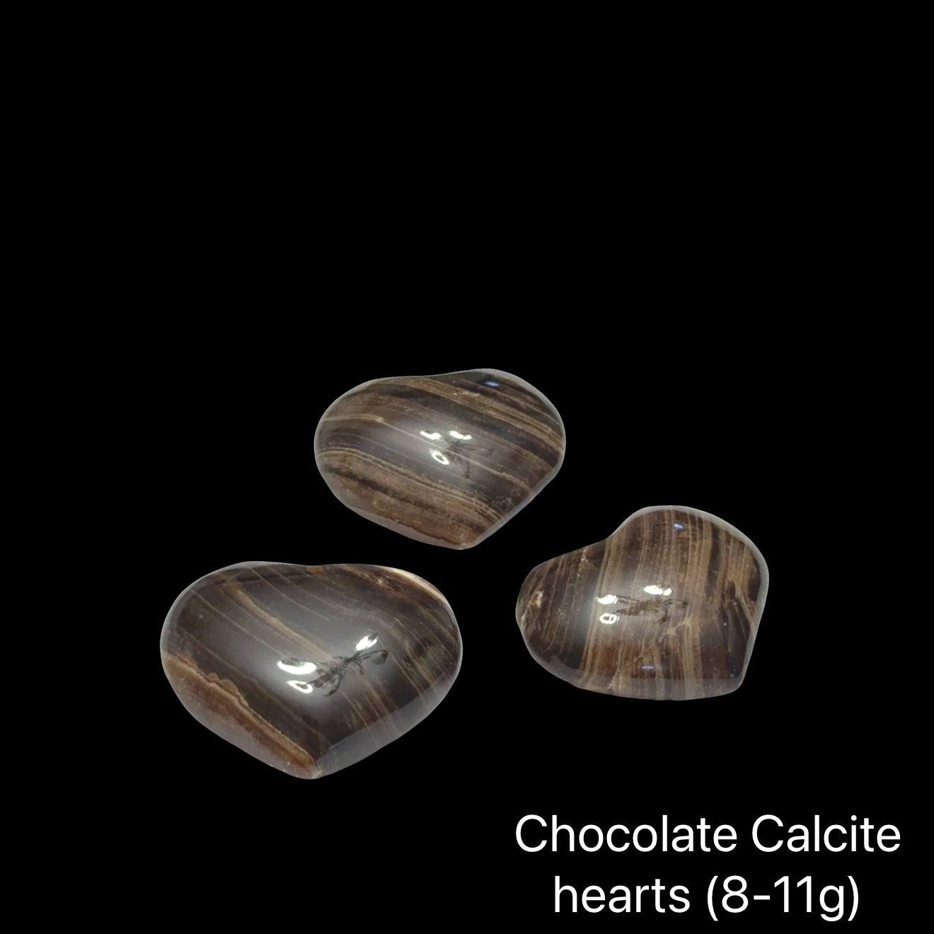 Three chocolate calcite hearts (8-11g) on a black background, front view.
