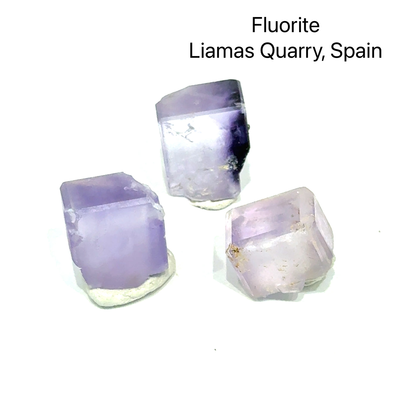 Three fluorite crystals from Liamas Quarry, Spain, on a white background, front view. 