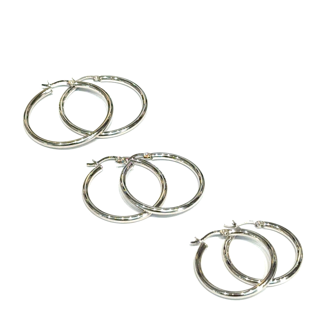 Three pairs of silver hoop earrings on a white background, front overview. 