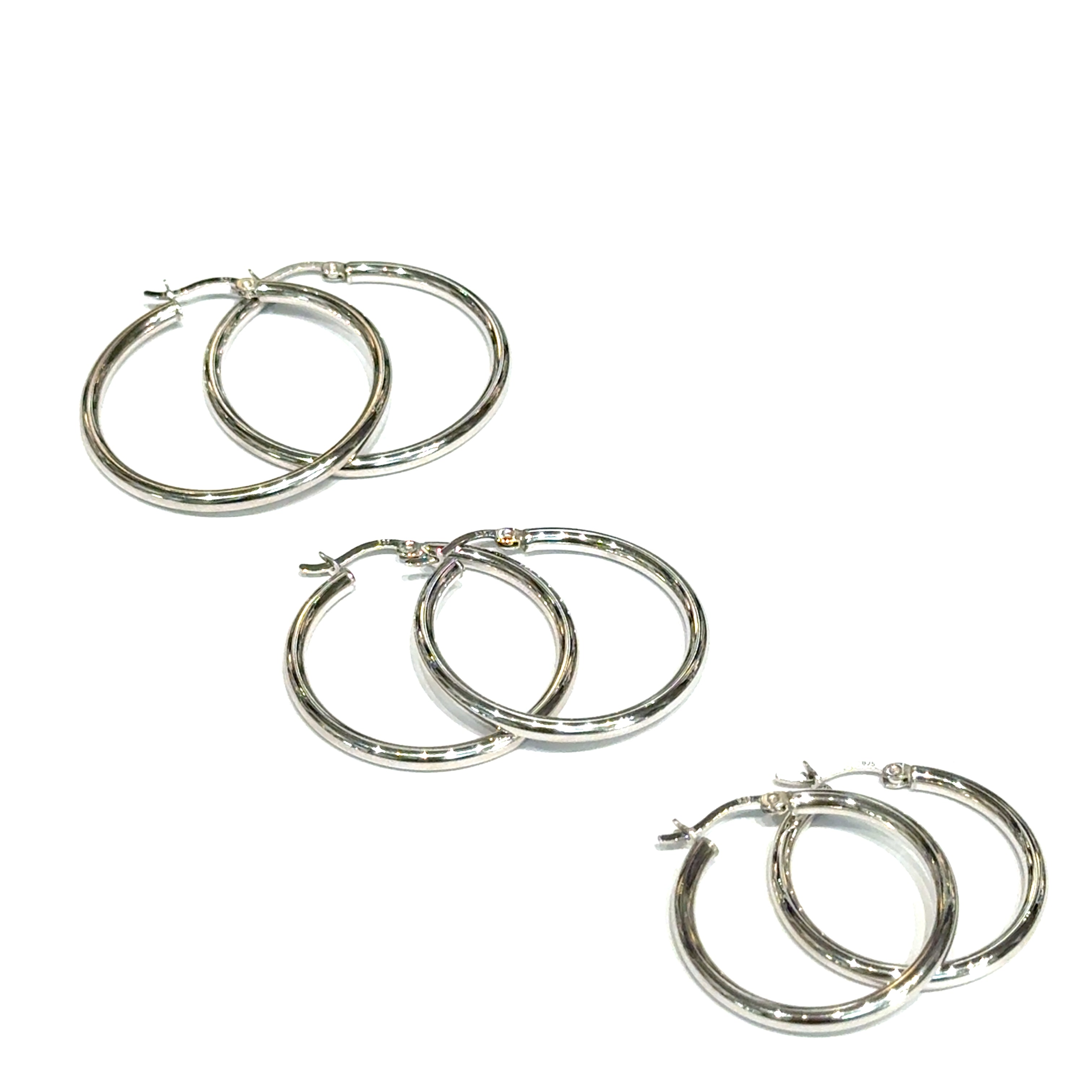 Three pairs of silver hoop earrings on a white background, front overview. 