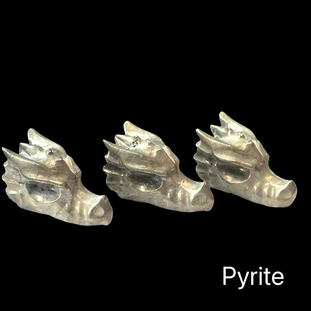 Three pyrite crystal dragon heads on a black background, front right-angle view.