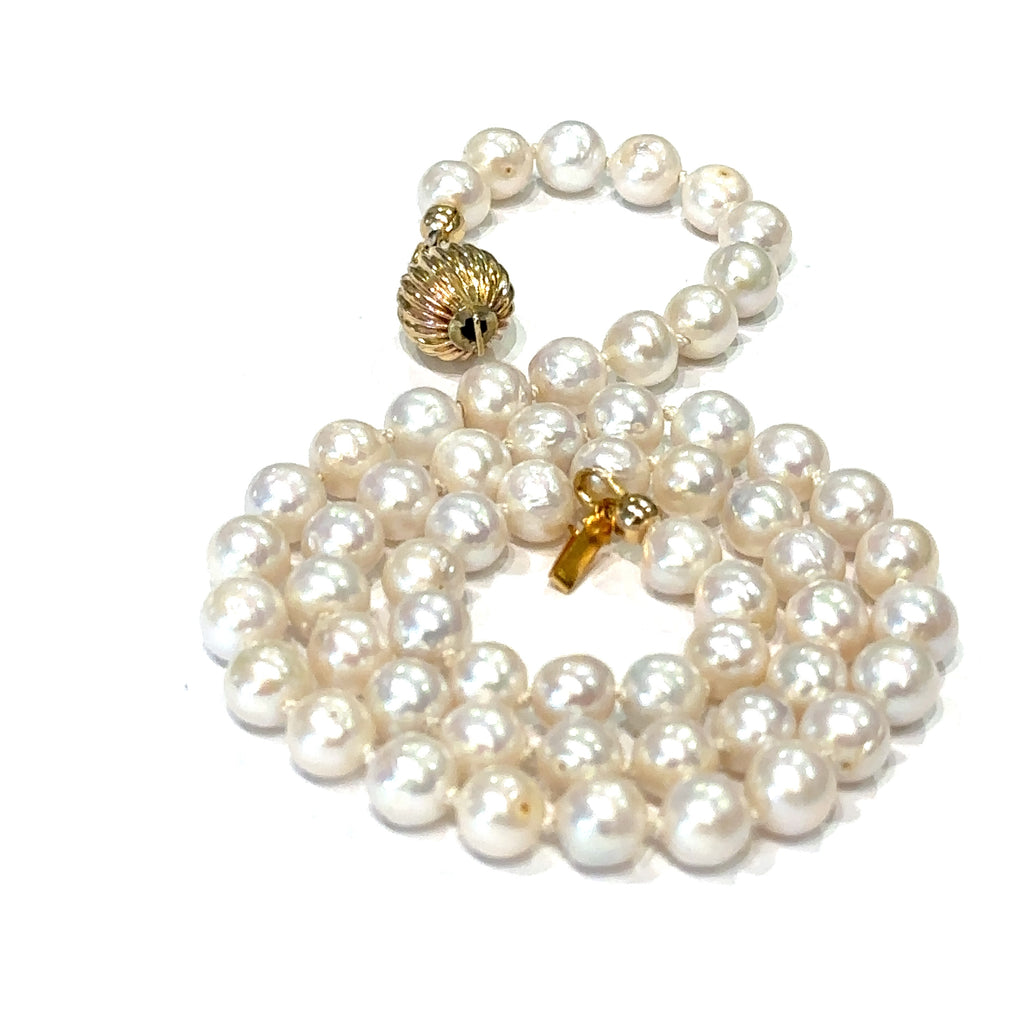 Top quality pearl necklace handmade in Boston jewelry shop on white spiral close up front overview 