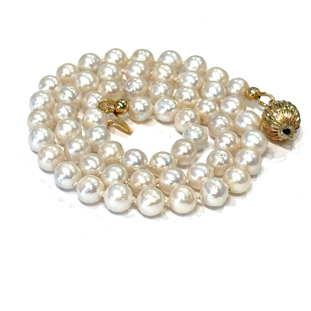 Top quality pearl necklace handmade in Boston jewelry shop on white spiral close up view 