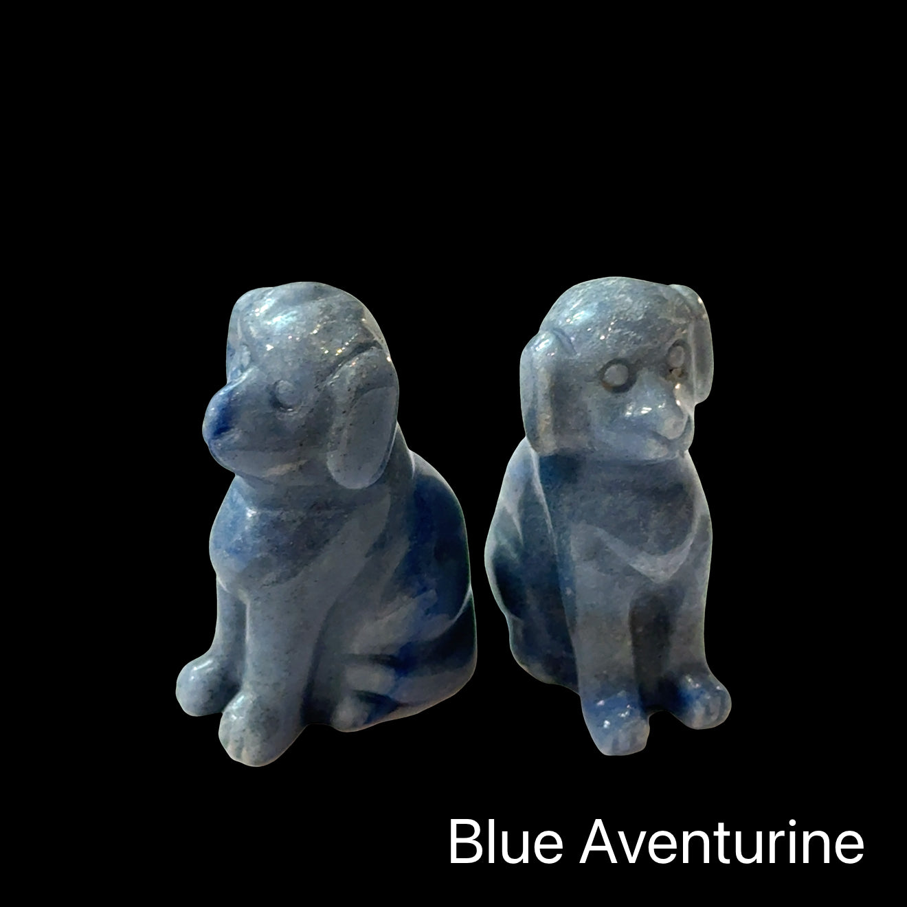 Two Blue Aventurine hound Dog gemstone carving on Black background, front view.