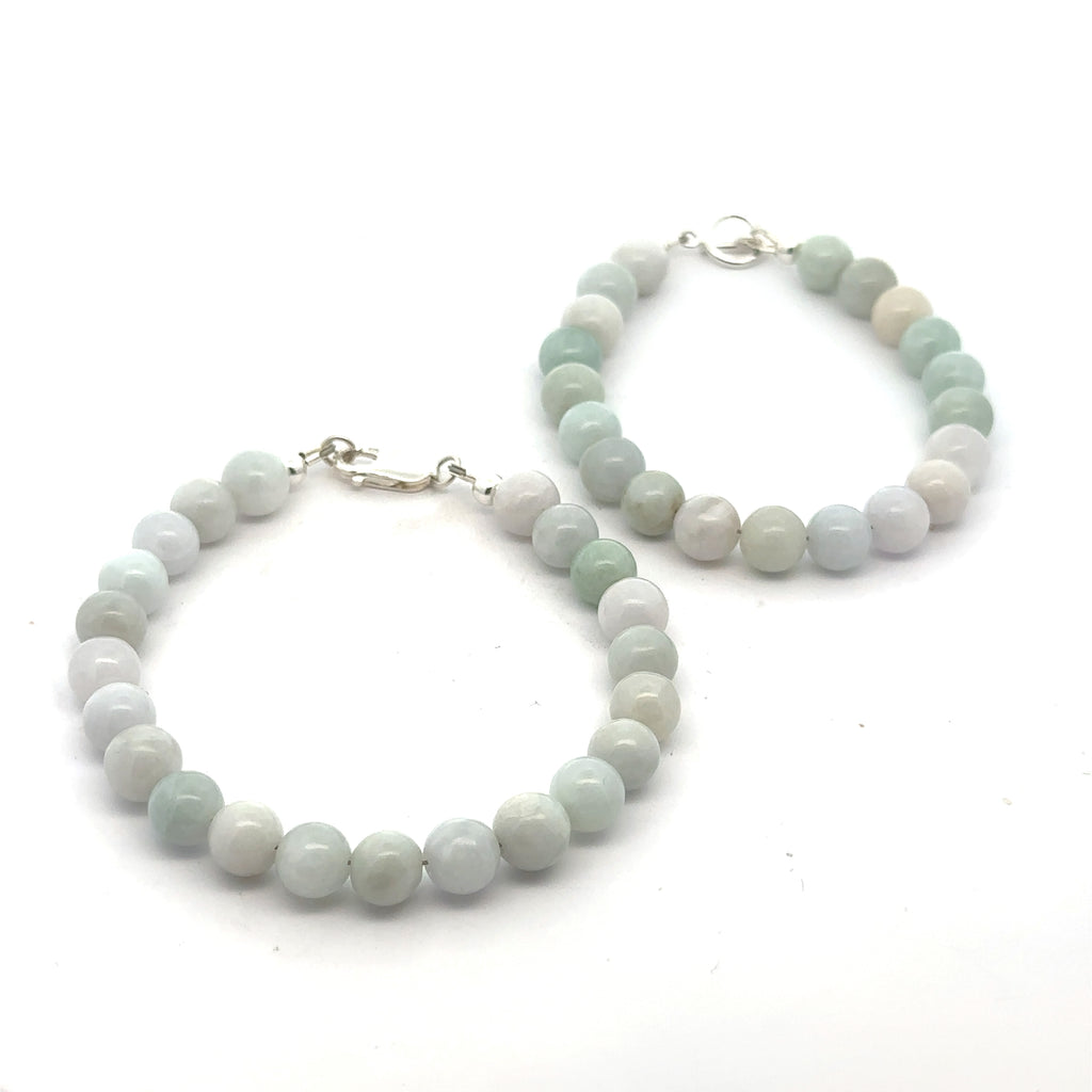 Two Burma jade gemstone beaded bracelet with sterling silver lobster claw and a toggle clasp on white background, front overview. 