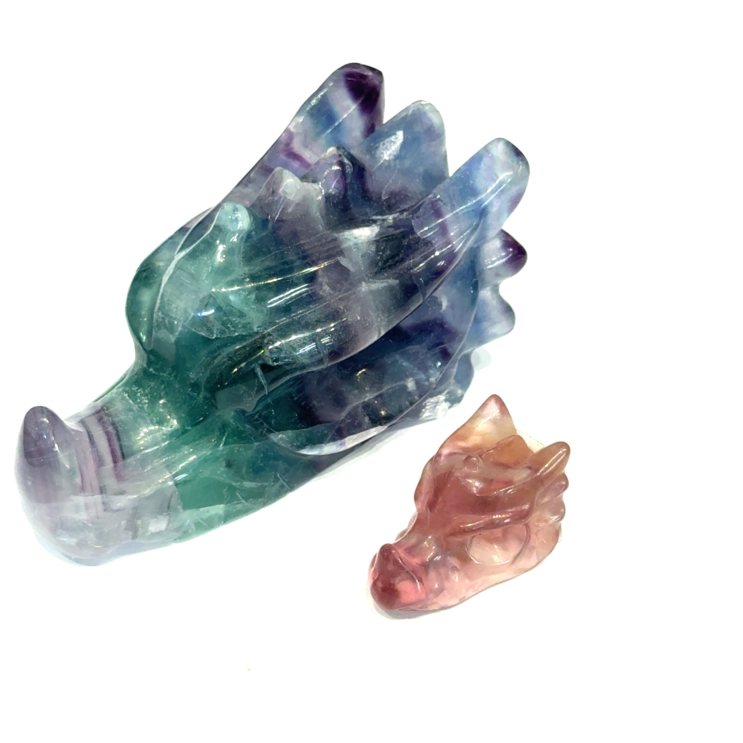 Two Rainbow Fluorite Gemstone Dragon Head carvings, on a white background, left angle front view.