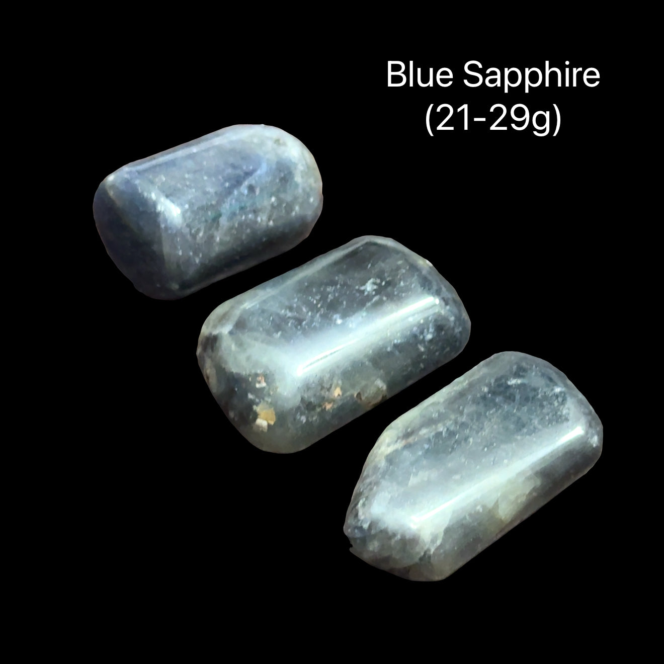 Two blue sapphires on a black background with text indicating weight range (21-29g), front view.