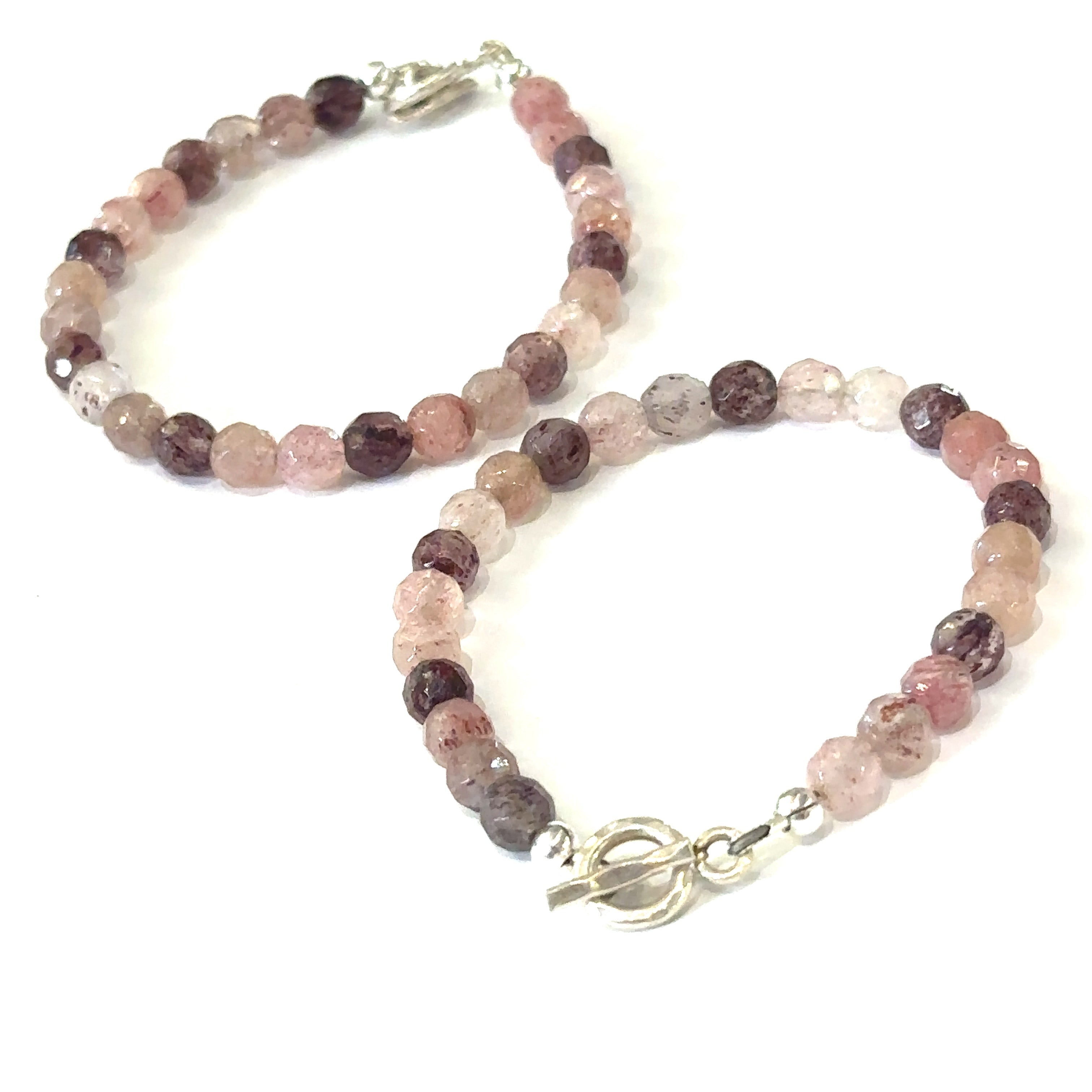 Two genuine Strawberry Quartz gemstone bracelets with faceted beads and a simple sterling silver circle toggle on a white background, center overview. 