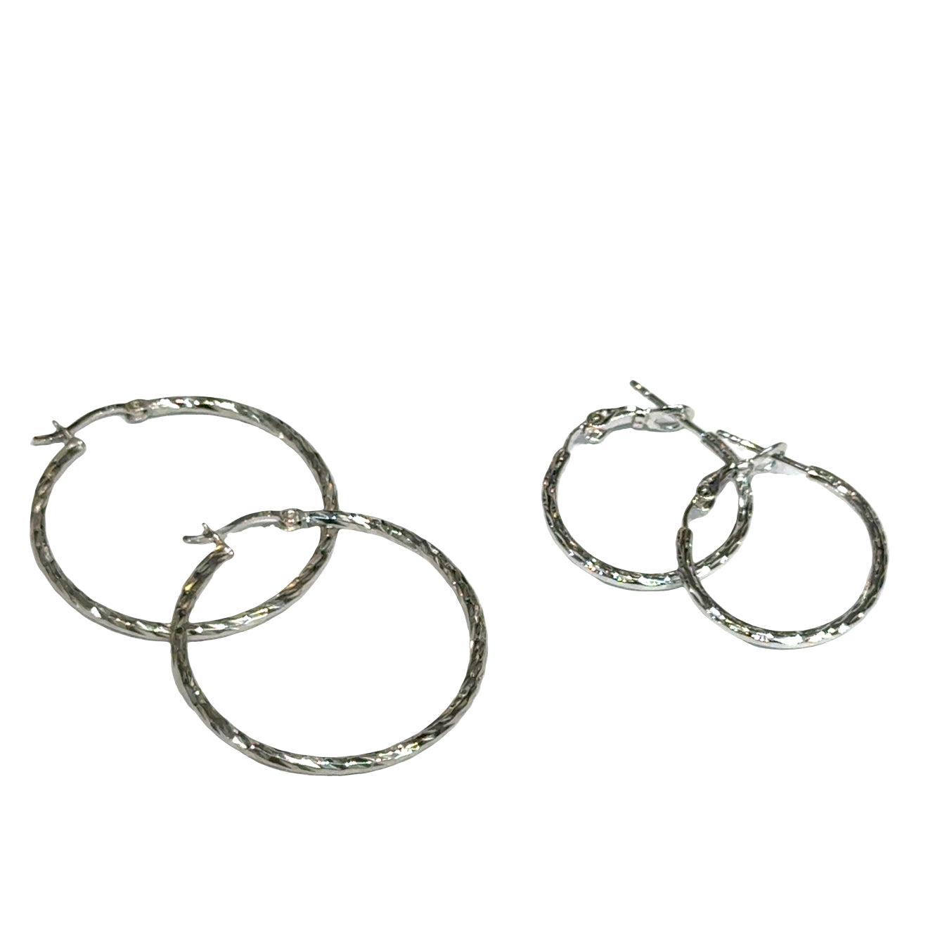 Two pairs of silver hoop diamond-cut earrings on a white background, front overview.