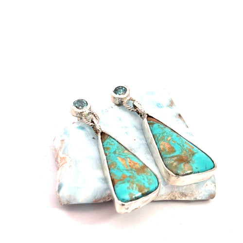 Blue Zircon and Royston Turquoise sterling silver drop earrings — handcrafted by Hidden Jewel South End on a white background lifted by a gemstone front slight angled right over view