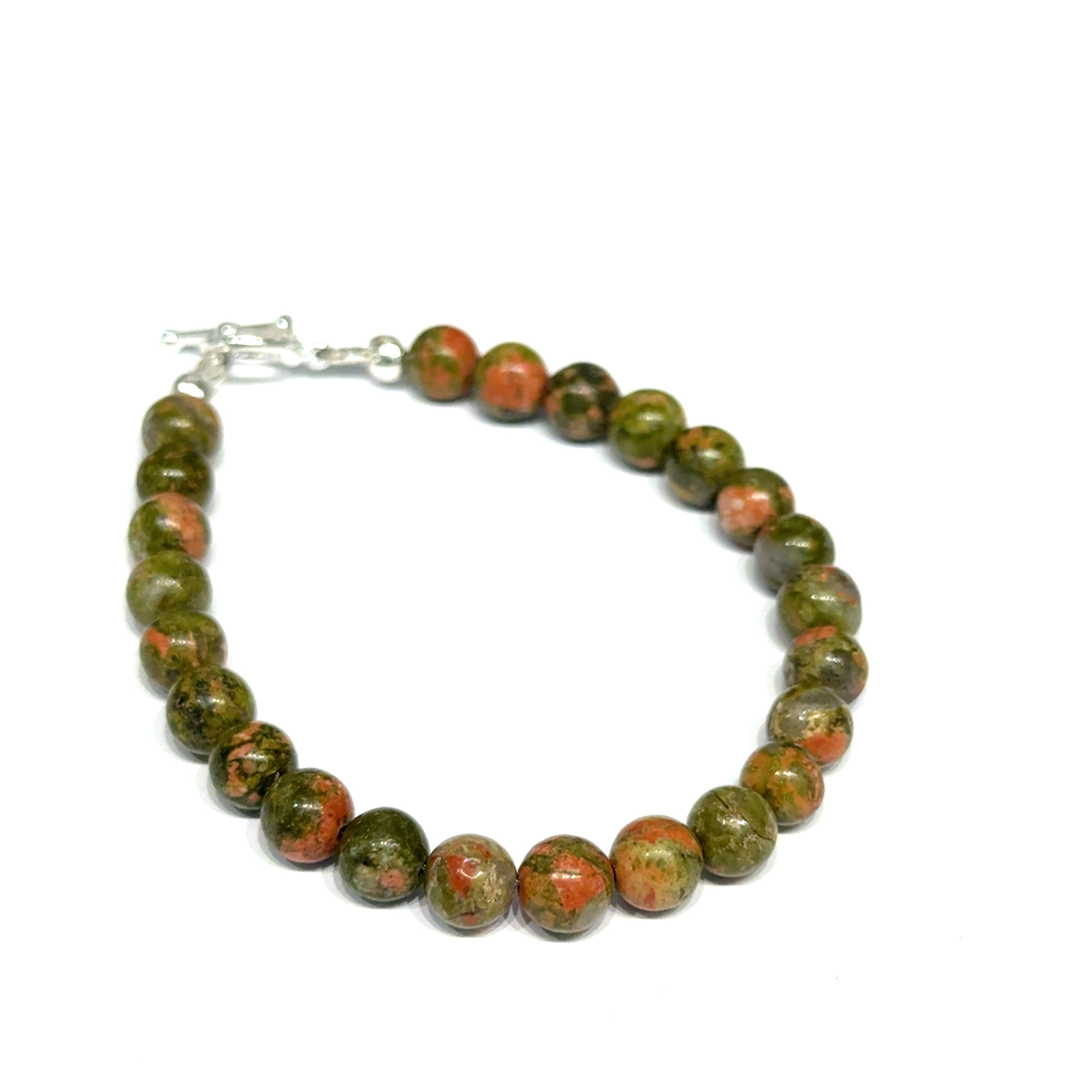 Unakite beaded bracelet with 6mm smooth round gemstones and a sterling silver toggle clasp for gentle emotional healing, on a white background, right angle close-up view. 