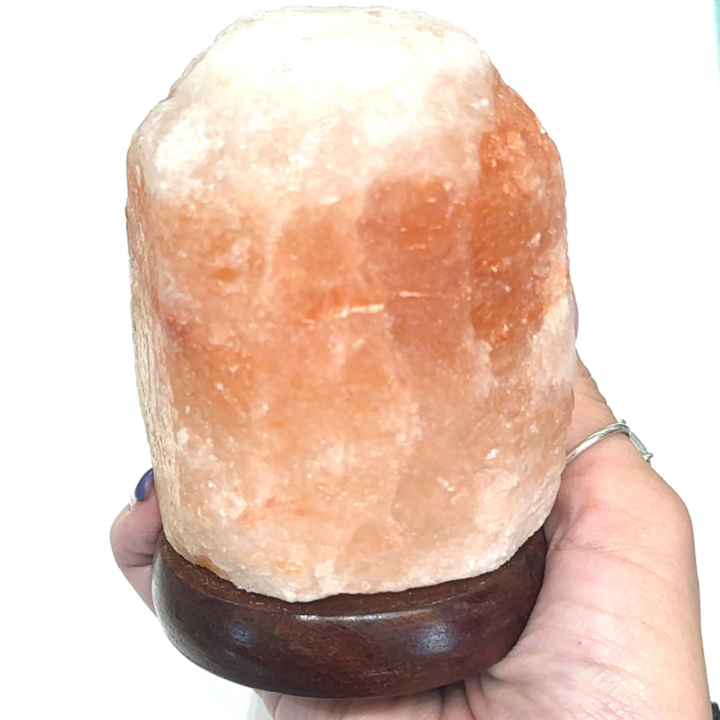 Unique Pink Himalayan Salt crystal lamp measuring 2.75'' x 4'' on white in hand front view