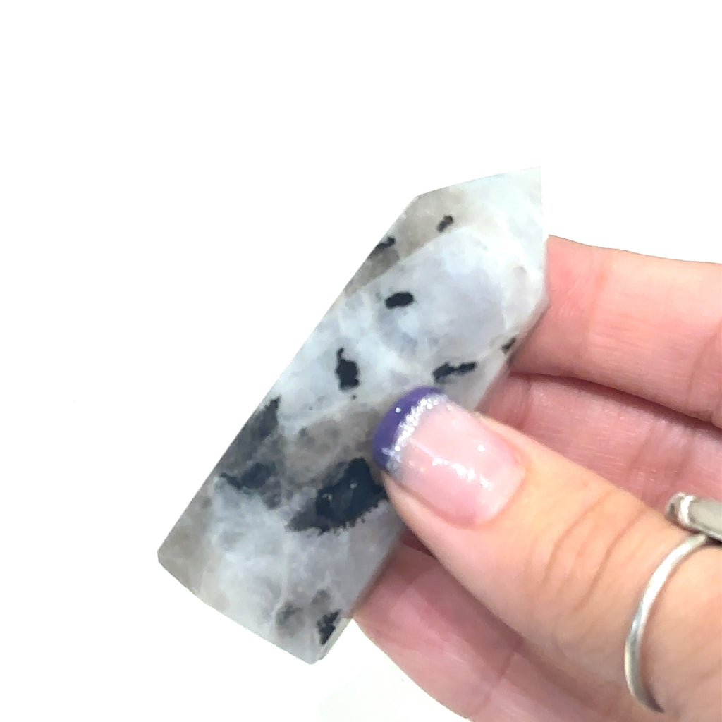 Unique Rainbow Moonstone tower crystal for emotional balance and spiritual protection on white in hand for close up view