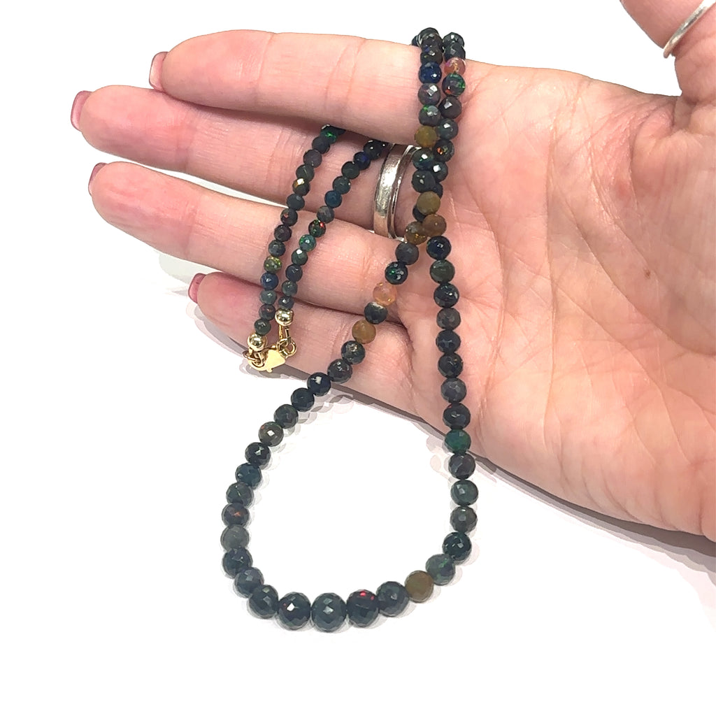Variegated Ethiopian Black Opal crystal necklace perfect for layering or solo wear on white in hand front view
