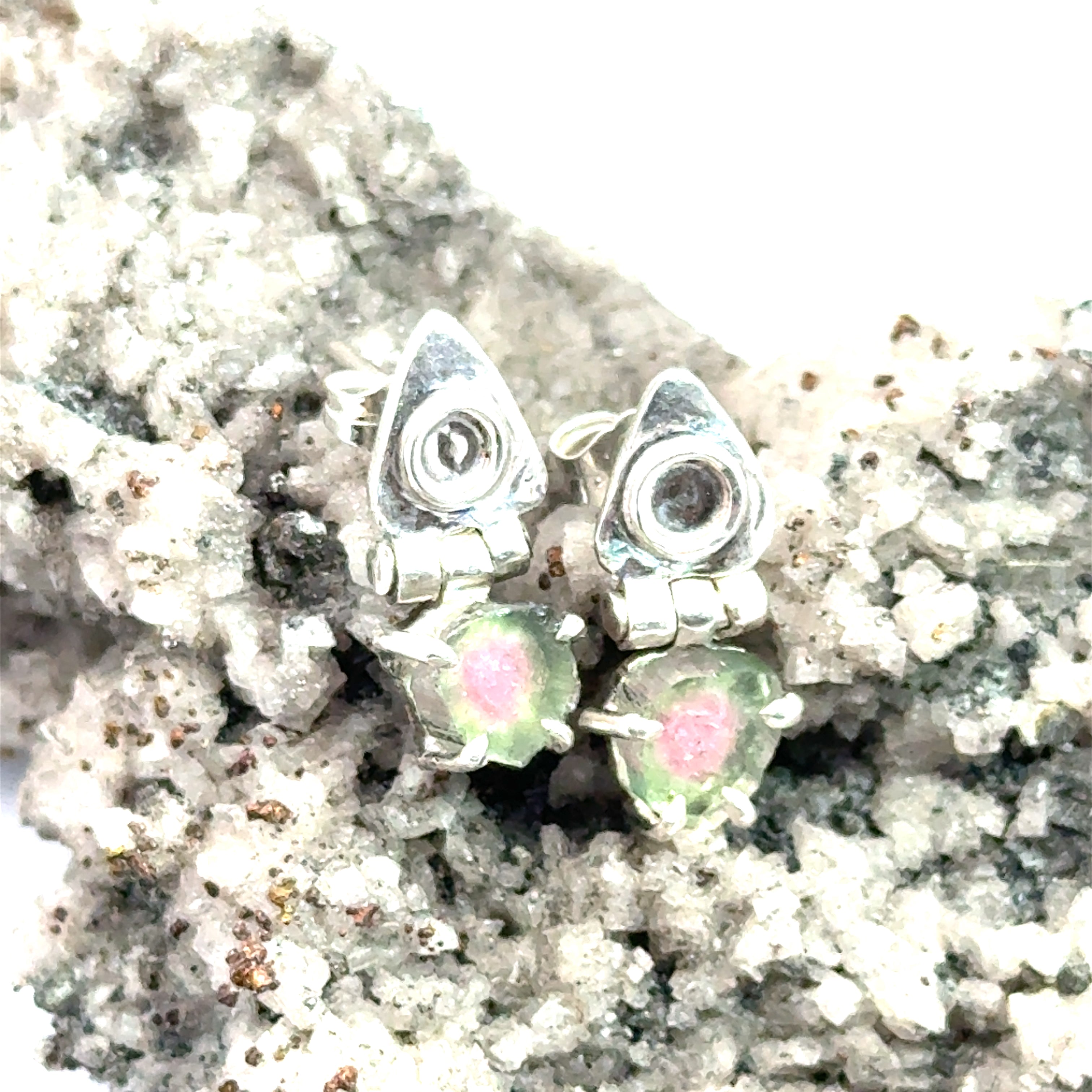 Watermelon Tourmaline Slice Earrings on white and rock up close front view 
