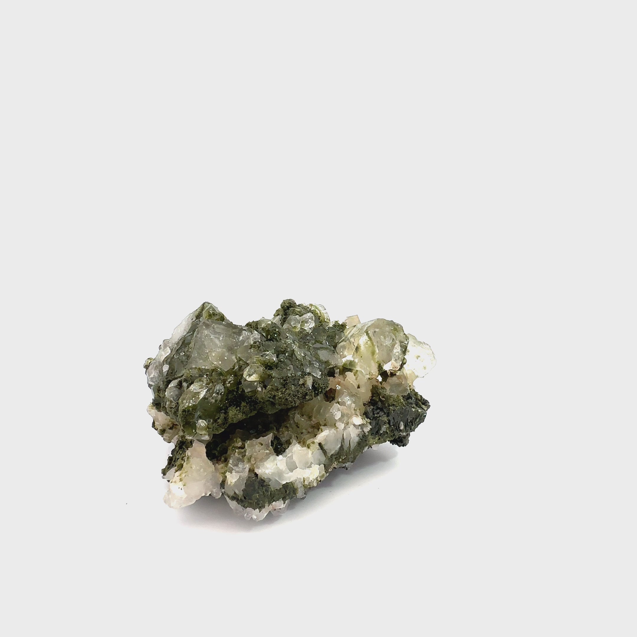 Epidote in Quartz Gemstone Cluster on white B-221g video