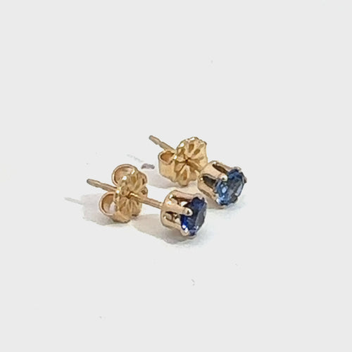 A pair of blue sapphire stud earrings with 14k gold-filled baskets and gold-filled push-backs on a white background, front overview. video