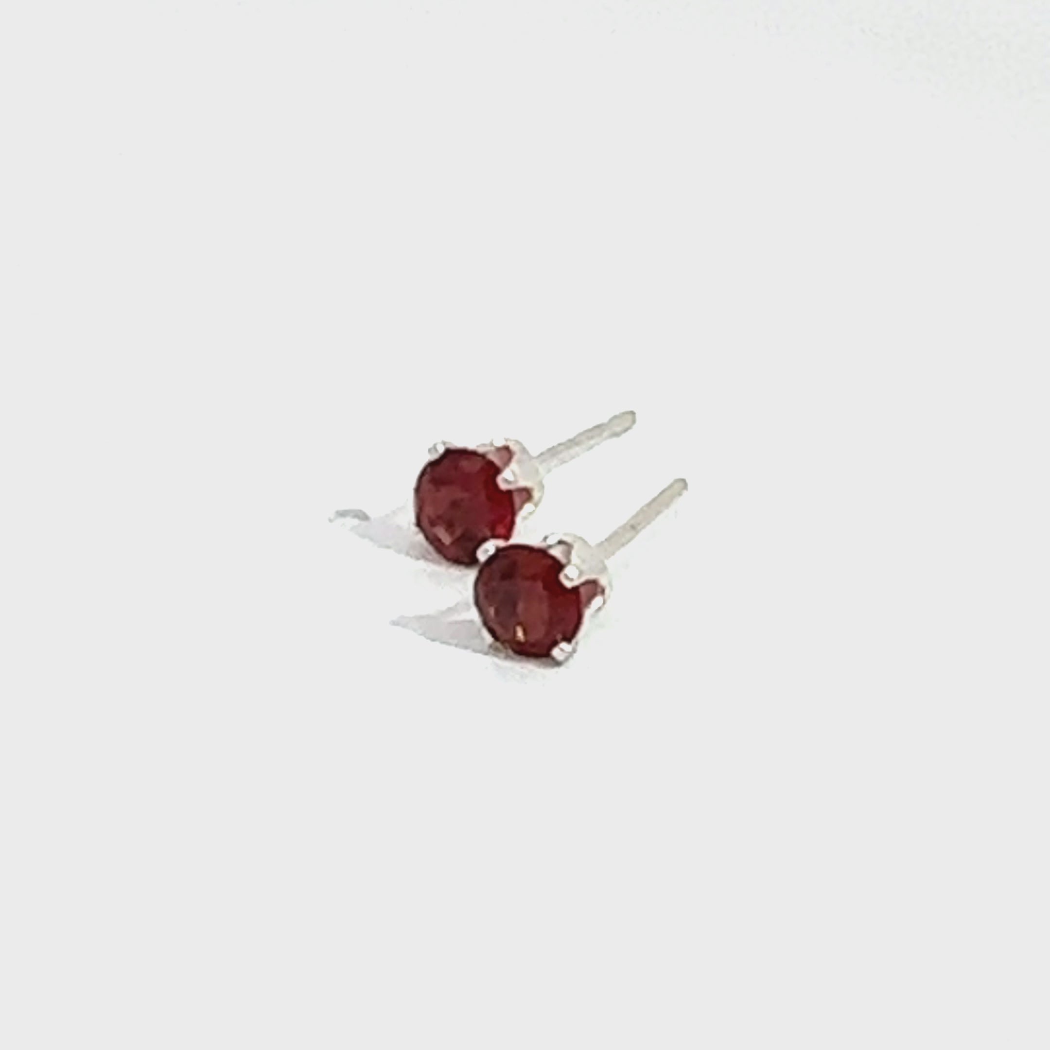 Faceted 4mm Garnet Post Earrings in Sterling Silver  Basket Setting 4 prong on white front left angled overview video