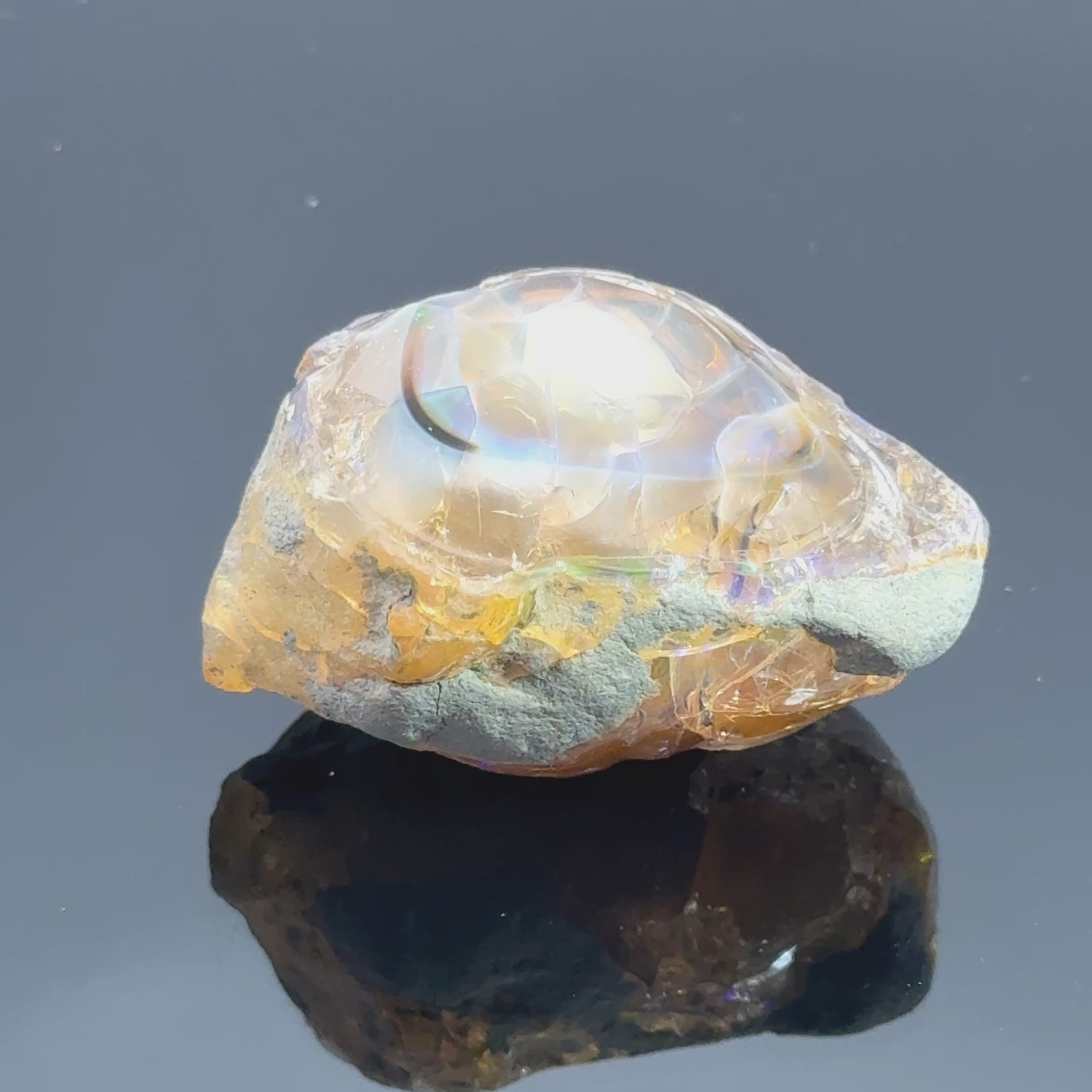 A raw Ethiopian opal gemstones with varying colors, displayed on a white background, video