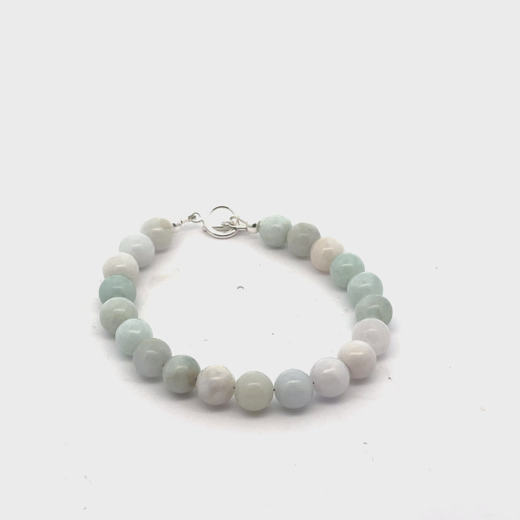 A Burma jade gemstone beaded bracelet with a sterling silver  toggle clasp on a white background, front overview video