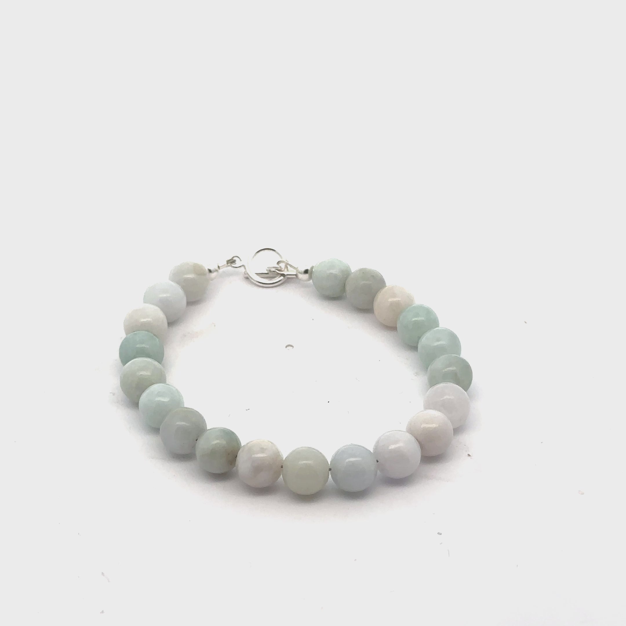 A Burma jade gemstone beaded bracelet with a sterling silver  toggle clasp on a white background, front overview video