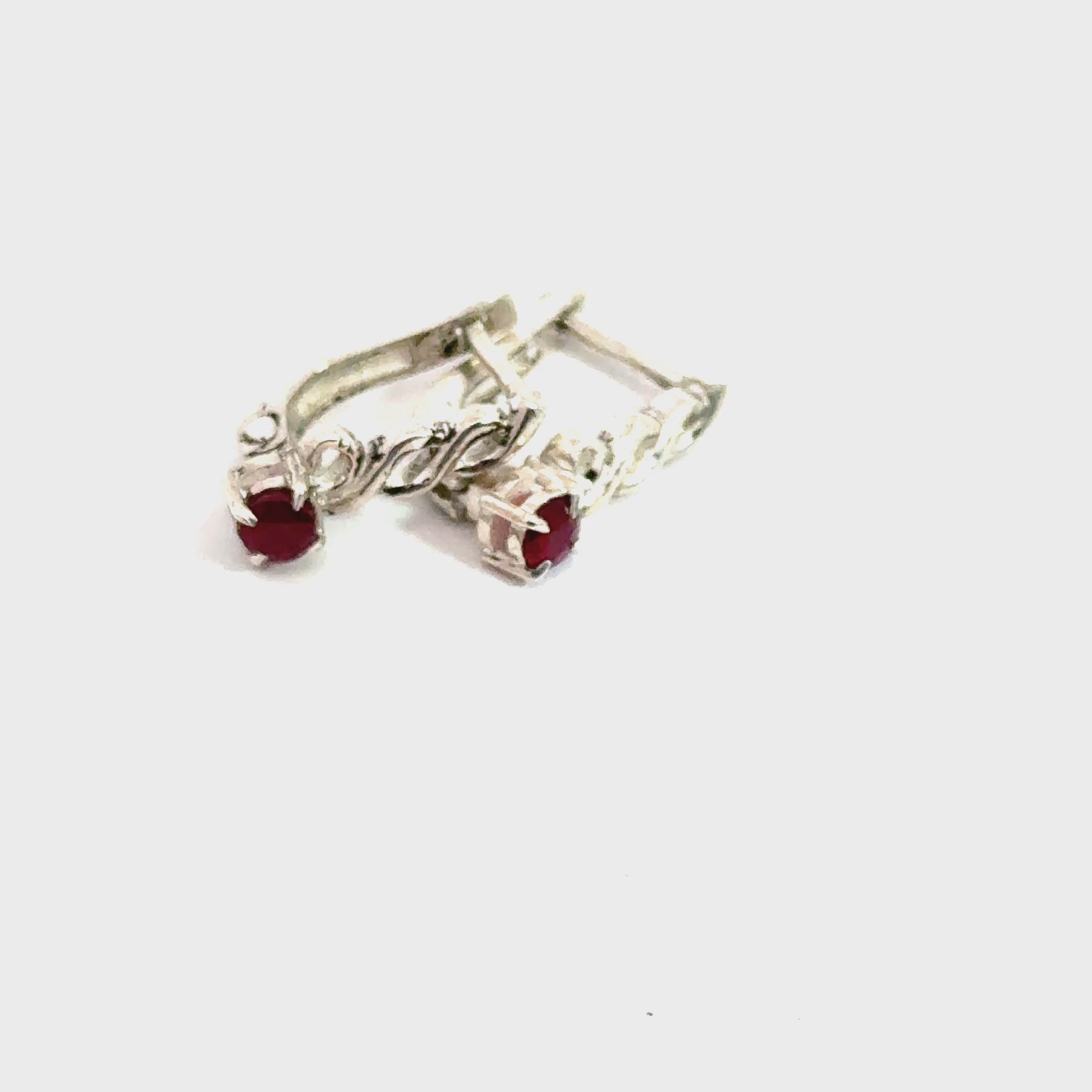 Faceted Ruby Snap‑Back Earrings on white and on rock sideway front view video