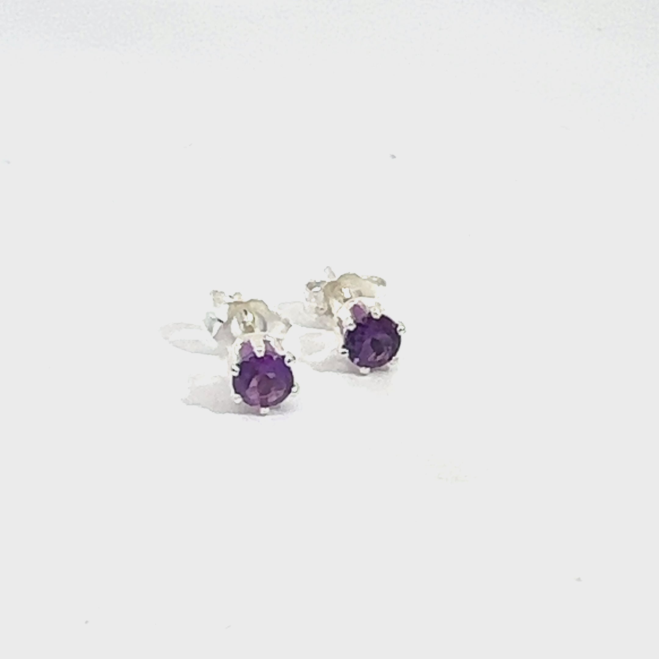 4mm faceted round Amethyst stud earrings in sterling silver 6-prong setting on a white background front overview video