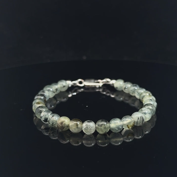 Close-up of natural prehnite beads displaying a soft green color and a smooth, polished finish, size 6.5, on a white background, video. 