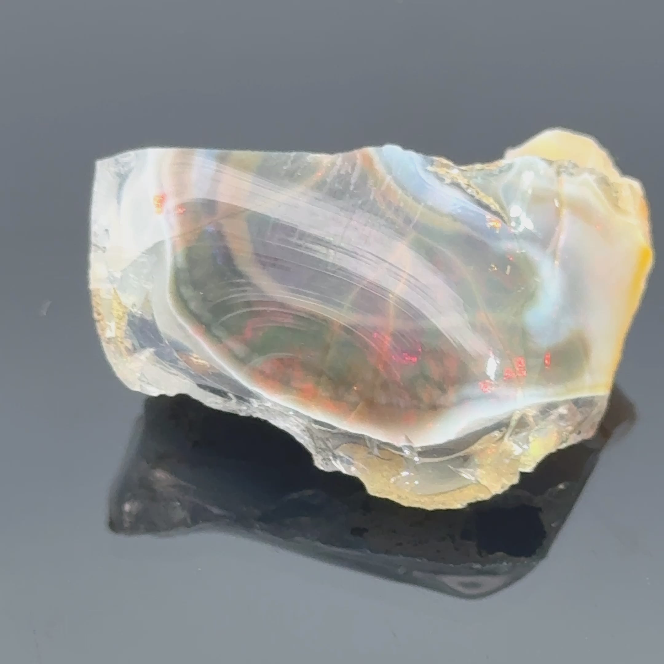 A raw Ethiopian opal gemstones with varying colors, displayed on a white background, video