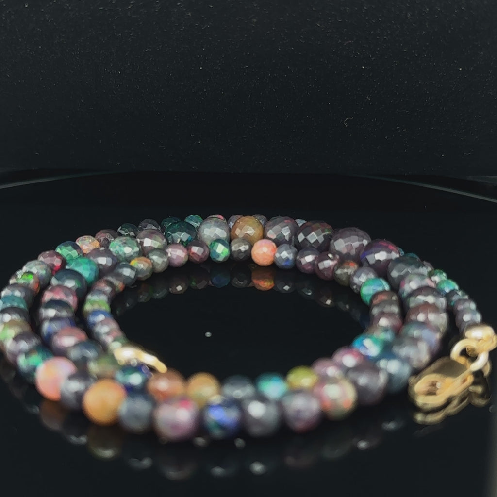 Genuine Ethiopian Black Opal faceted gemstone necklace with gold‑filled lobster clasp, 18 inches long on black spiral center  overview video