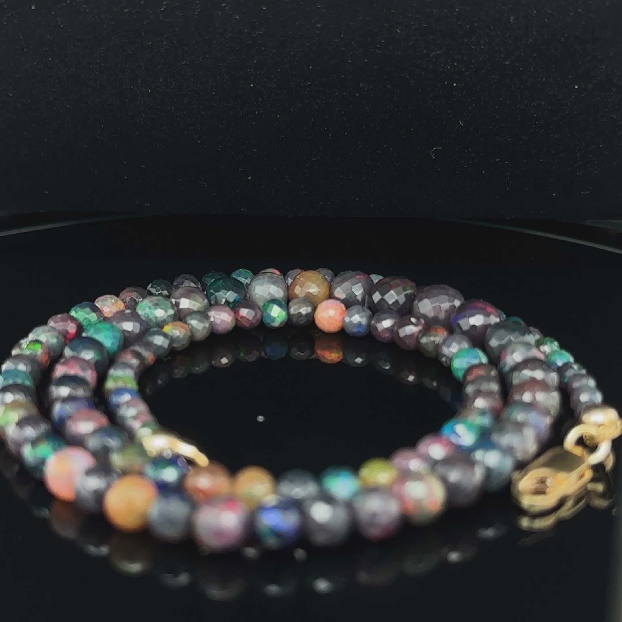 Genuine Ethiopian Black Opal faceted gemstone necklace with gold‑filled lobster clasp, 18 inches long on black spiral center  overview video