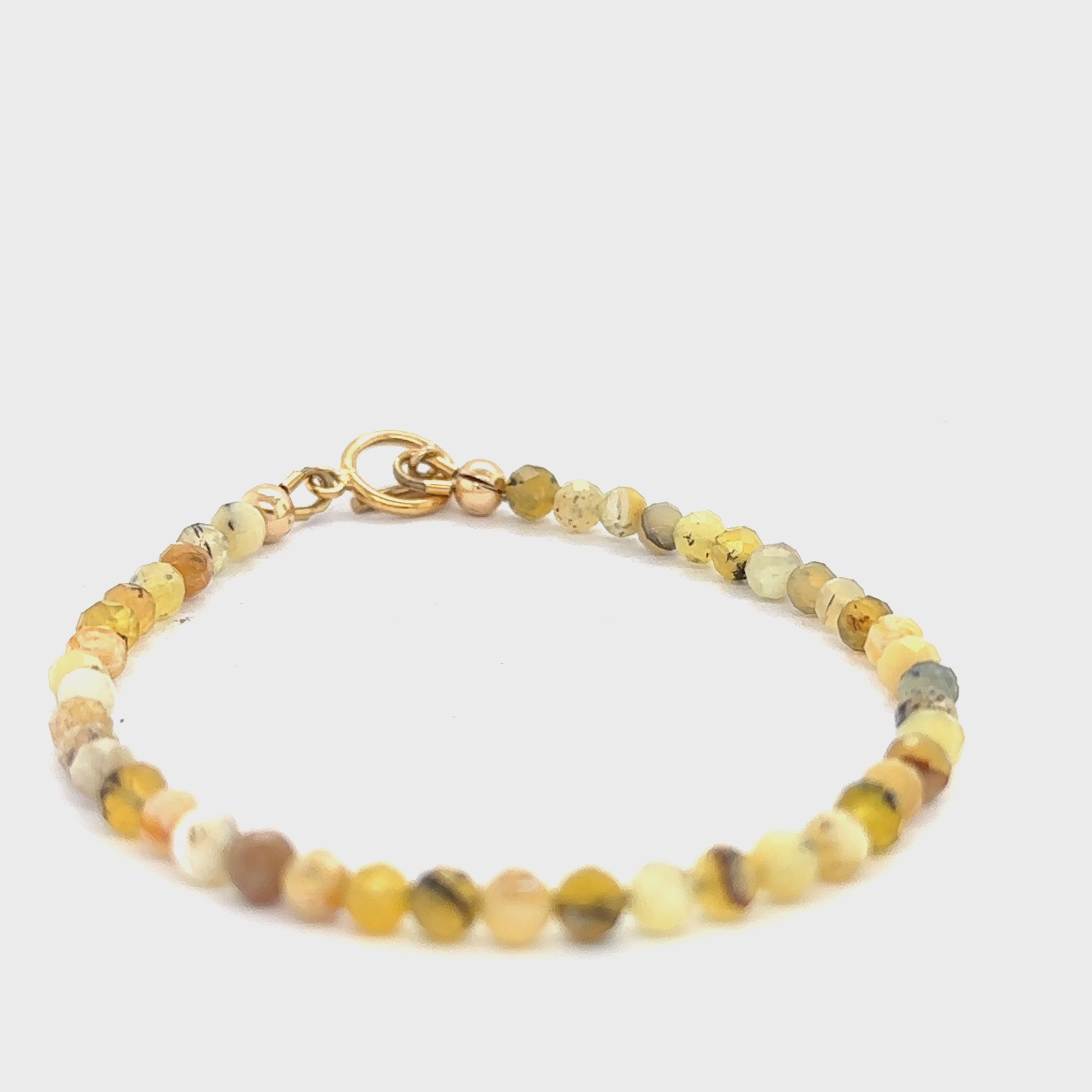 A yellow opal gemstone beaded bracelet with a gold-filled simple circle toggle, size 6.5. on a white background, front view video