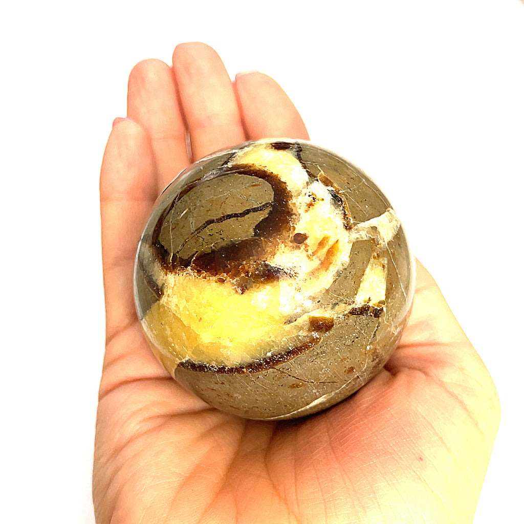 #1 A gemstone sphere displayed in a model's palm on a white background in front view.