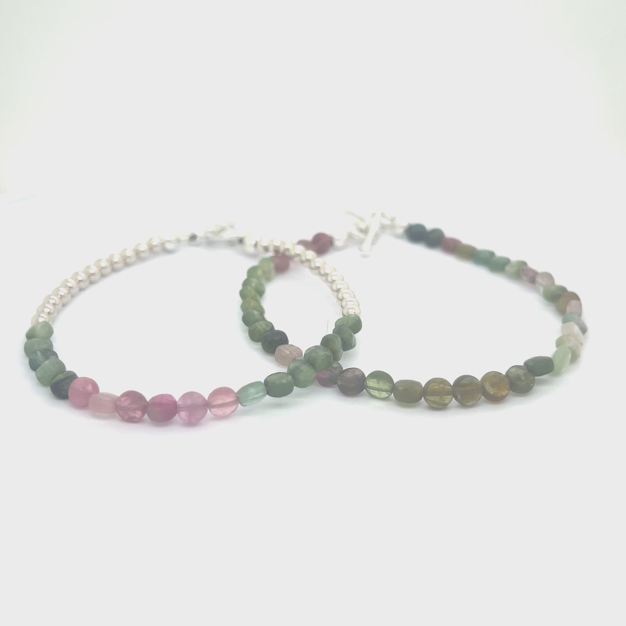 A bracelet with faceted watermelon tourmaline circles and sterling silver beads, featuring a sterling silver toggle clasp, on a white background front overview. video