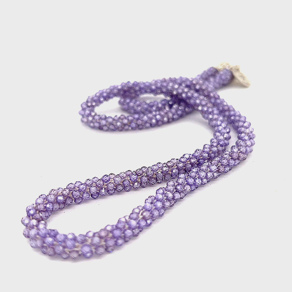 A purple zircon gemstone crocheted necklace with a sterling silver toggle, on a white background. A long front overview. video
