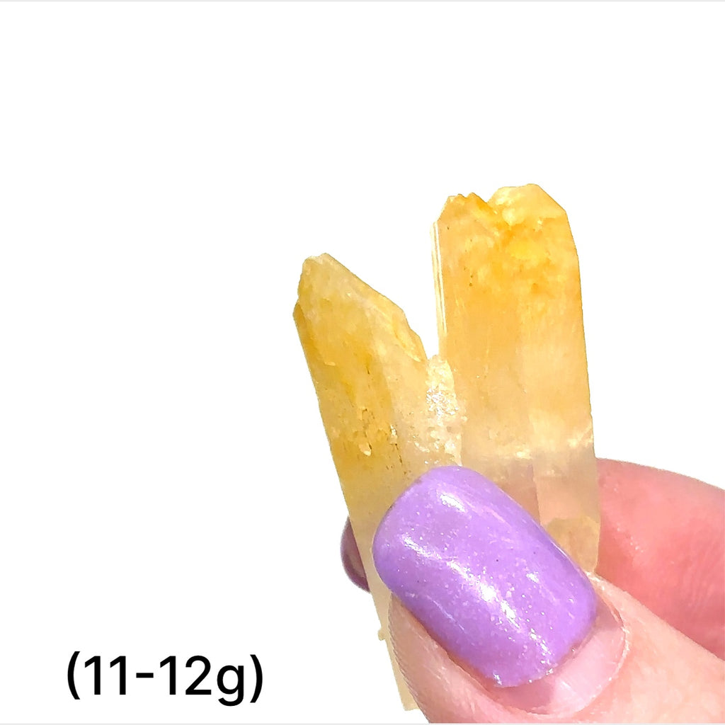 A collection of Halloysite-Included Quartz gemstones, also known as 'Mango Quartz', sizes (11-12g) is displayed on a white surface center overview.