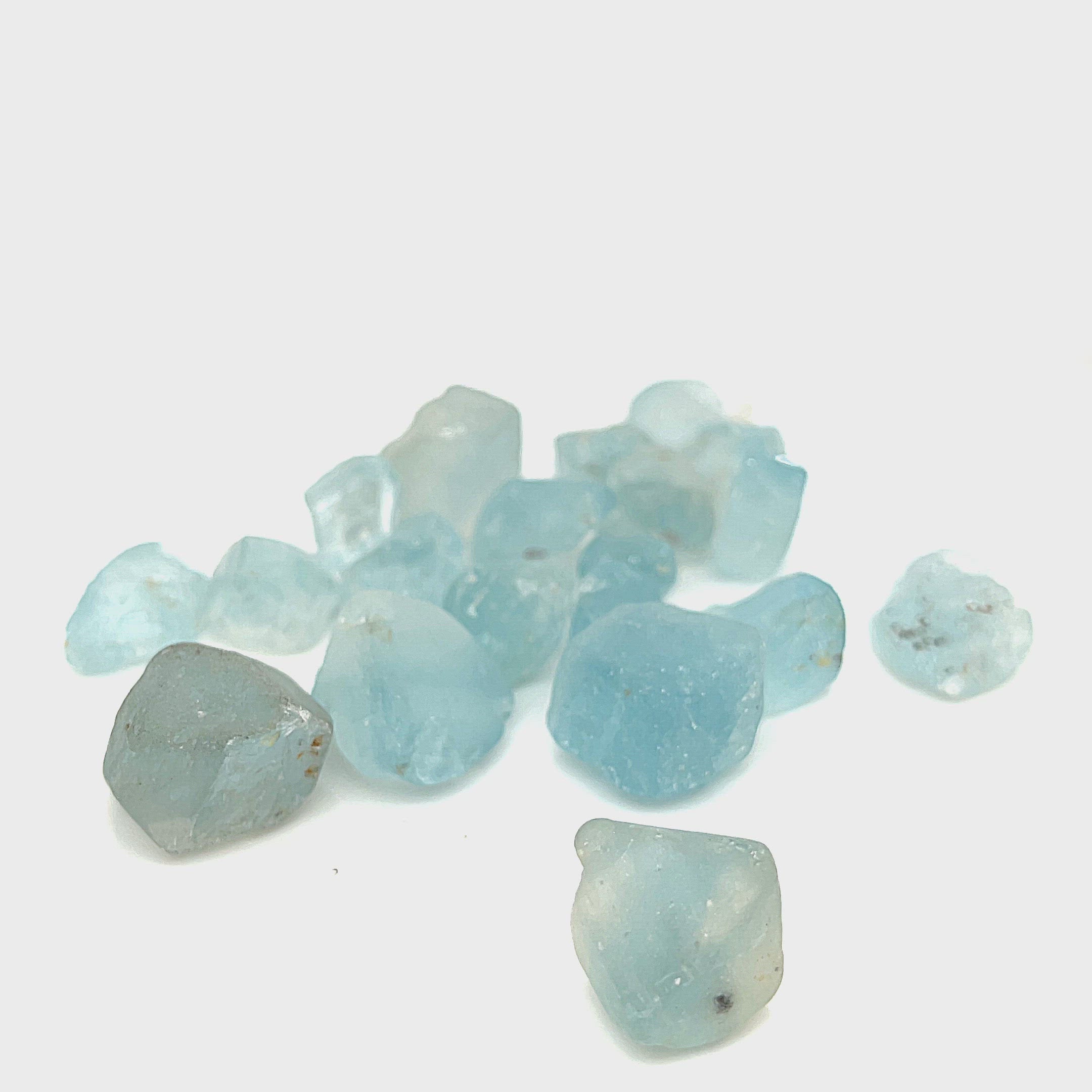 Raw Blue Topaz Gemstone on white grouping center up close front view of video