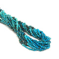 2mm Chrysocolla faceted round gemstone strand, on a white background, overview. 
