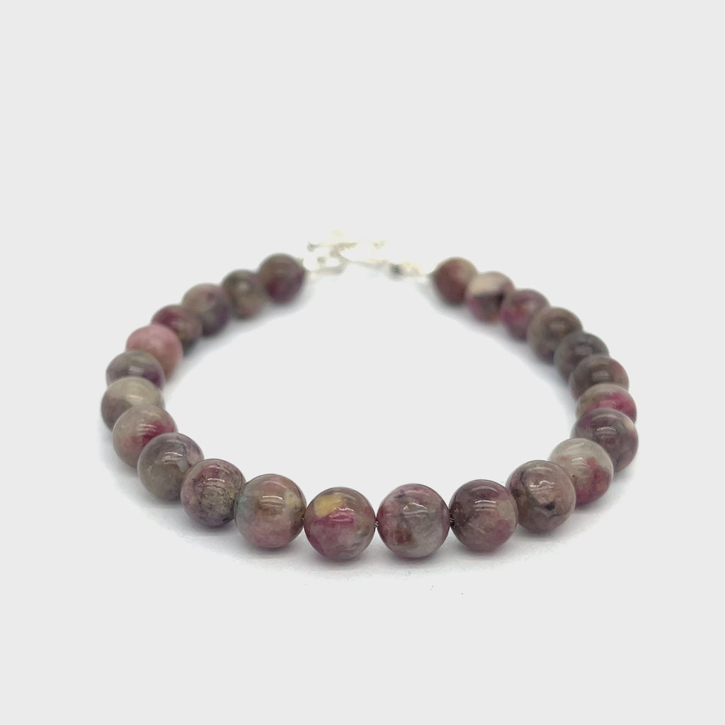 A Eudialyte gemstone beaded bracelet with a sterling silver toggle on a white background front overview video